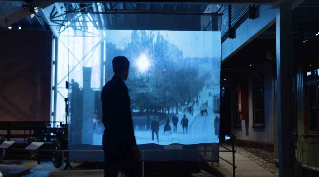 silhuett av mann ser på reklamefilm på en projektor. Foto